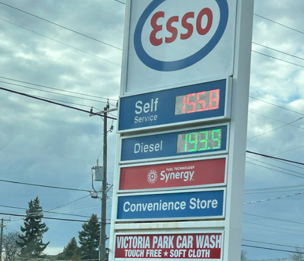 Picture10 - Toronto Bangla Town | Digital Bangla Weekly Magazine Esso gas station sign listing Self Service and Diesel prices, with Synergy branding and a Convenience Store sign.