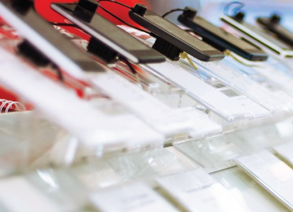 Picture6 - Toronto Bangla Town | Digital Bangla Weekly Magazine Close-up of clear plastic price tag holders with black clips in a retail display rack, blurred background outside focus.