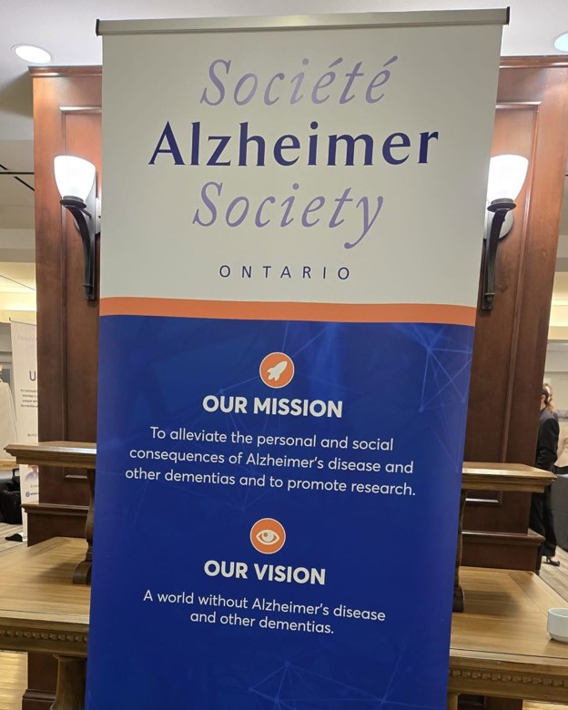 Picture7 - Toronto Bangla Town | Digital Bangla Weekly Magazine Banner for the Alzheimer Society Ontario detailing its mission to alleviate dementia impacts and promote research, with a blue section listing the vision for a world without Alzheimer's and other dementias and a white section above showing the organization name.