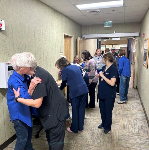 Picture4 - Toronto Bangla Town | Digital Bangla Weekly Magazine Hospital hallway full of staff and visitors, several people lined up at a table, some hugging and helping at a station.