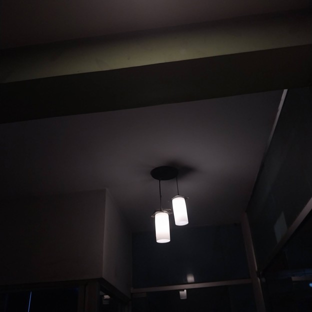 Picture9 - Toronto Bangla Town | Digital Bangla Weekly Magazine Two cylindrical pendant lights hang from a dark ceiling in a dim indoor space, casting soft glow.